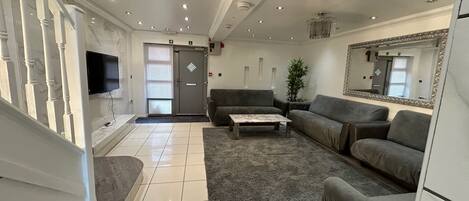 A modern living room with a sofa, coffee table, and a television.