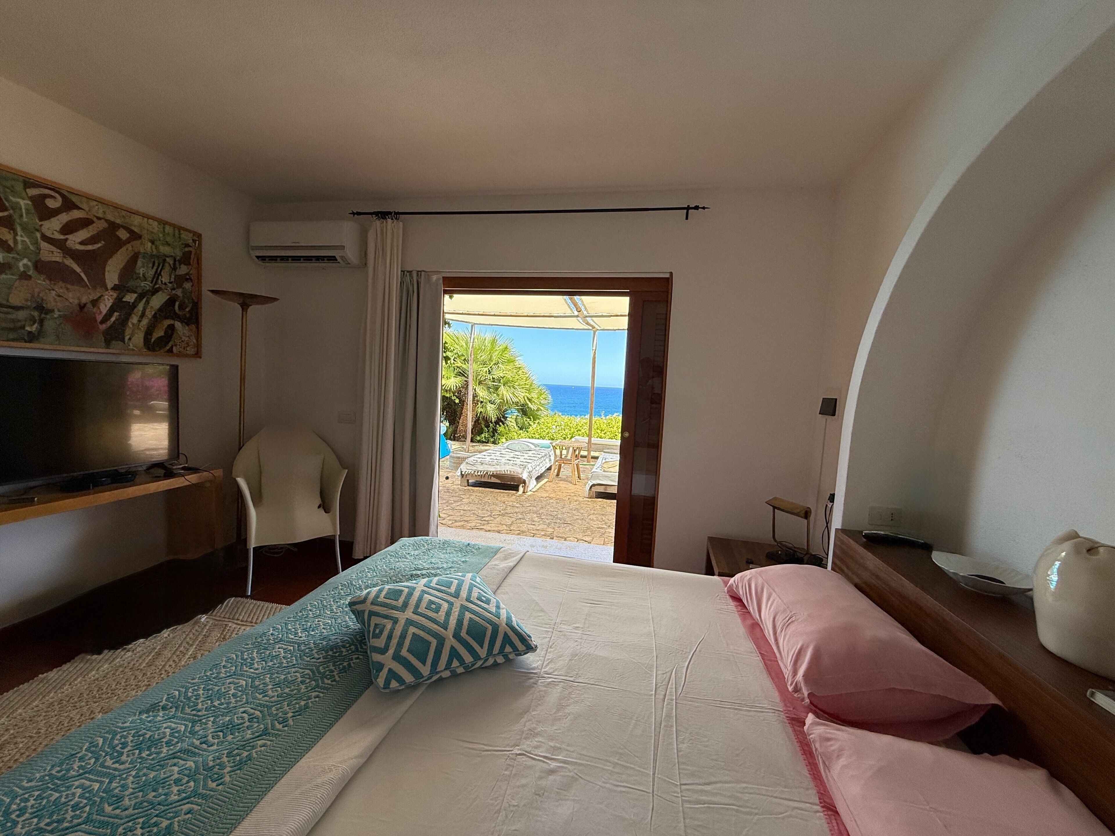 Una camera da letto con un letto, una TV, una scrivania e vista sull'esterno.