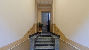 Una scala in marmo con ringhiera che conduce a una porta.
