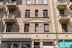 A multi-story building with balconies, a central entrance, and a ground-level shop. - Molinette e Lingotto Studio by Wonderful Italy (Turin)