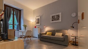 Un soggiorno moderno con un divano, un tavolo da pranzo e una televisione.