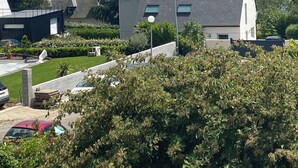 A residential area with modern houses, a clear blue sky, and a view of the sea.