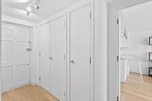 A hallway with white doors, a white drying rack, and a white shelf unit. - Belgravia Living 2-bed, 2-bath Fourth Floor Apartment (London)