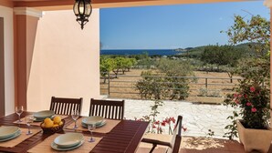 A table set for dining with a view of the sea and a garden. - Nice Villa in Sant Carles With Pool (Santa Eulalia del Rio)