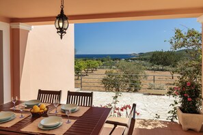 A table set for dining with a view of the sea and a garden. - Nice Villa in Sant Carles With Pool (Santa Eulalia del Rio)