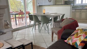 Un salon comprenant un canapé, une table basse et un coin repas avec des chaises et une table.
