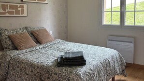 Une chambre à coucher avec un lit, une fenêtre et un radiateur.