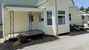 A single-story house with a green roof, a covered porch, and a small front yard. - 3-bedroom Cozy Home Close to Santa Claus, IN and Holiday World (Ferdinand)