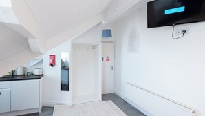 Une chambre d’hôtel moderne équipée d’un téléviseur à écran plat, d’un coin cuisine et d’un escalier.