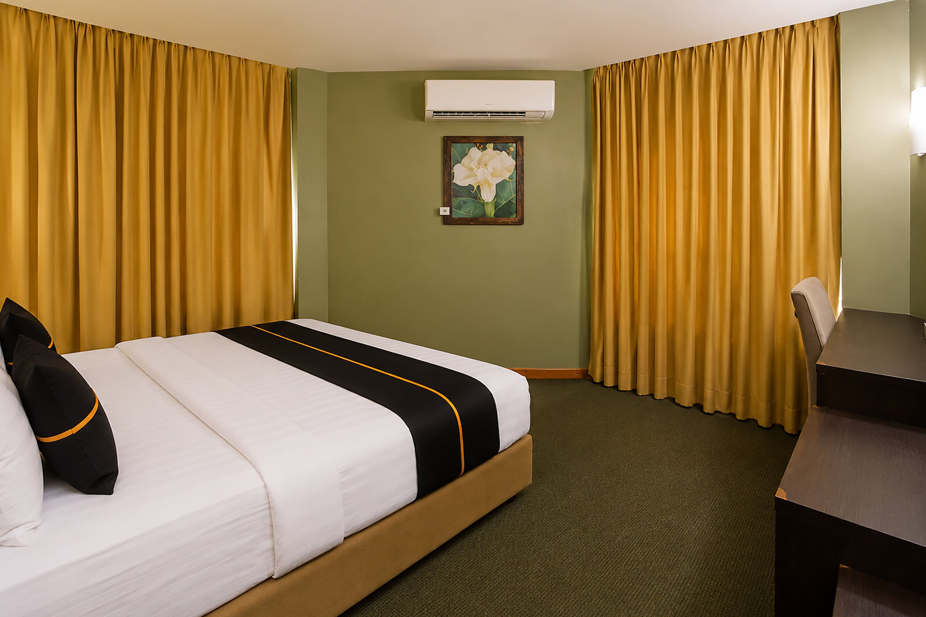 Une chambre d’hôtel avec un lit, un bureau et des rideaux.
