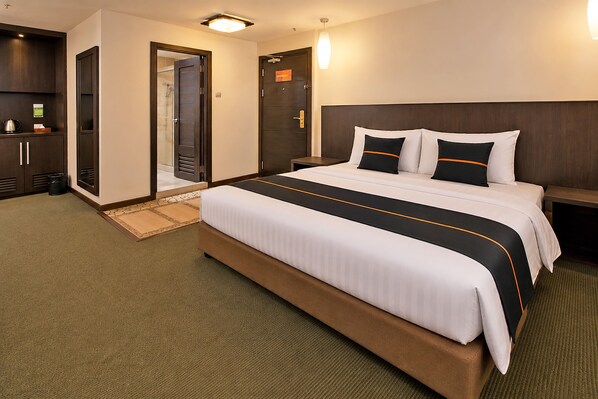 A hotel room with a large bed, a wooden headboard, a nightstand, and a wardrobe. - Townhouse Near Tanjung Batu Formerly 900 Inn (Bintulu)