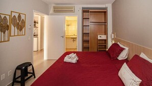 Et hotelværelse med en seng, et skab og et badeværelse, der kan ses gennem en åben dør.