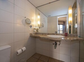 A bathroom with a sink, mirror, towel rack, toilet, and a roll of toilet paper. - SHB - Varanda Piscina e Por do Sol (Santos)