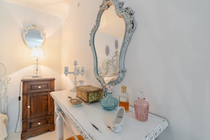 A bathroom with a wooden cabinet, a mirror, a vanity, and various toiletries. - Grandma's House with Wi-Fi and Air Conditioning (Syracuse)