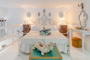 A bed with a decorative headboard, bedside tables, a mirror, and a suitcase on the floor. - Grandma's House with Wi-Fi and Air Conditioning (Syracuse)