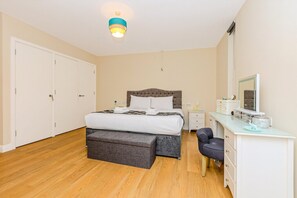 Ein Schlafzimmer mit Bett, Schreibtisch, Stuhl, Kleiderschrank und Deckenleuchte.