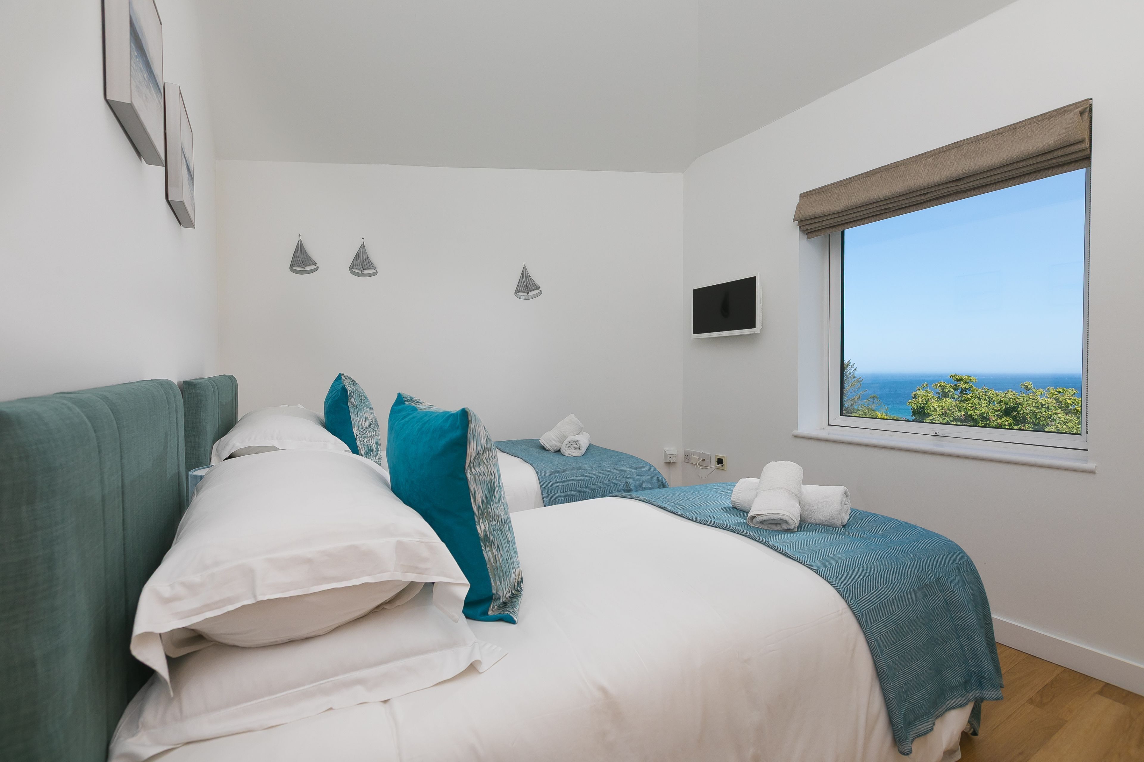 Ein Schlafzimmer mit zwei Betten, einem Fernseher und einem Fenster mit Blick.