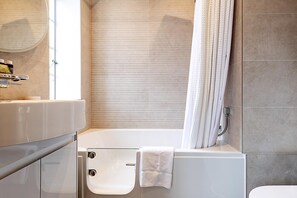 A modern bathroom with a bathtub, a shower, and a toilet. - Stylish Chelsea Flat Near Sloane Square (London)