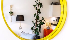 A room with a potted plant, a lamp, a radiator, and a cabinet. - Chic East London Stay With Outdoor Space (London)