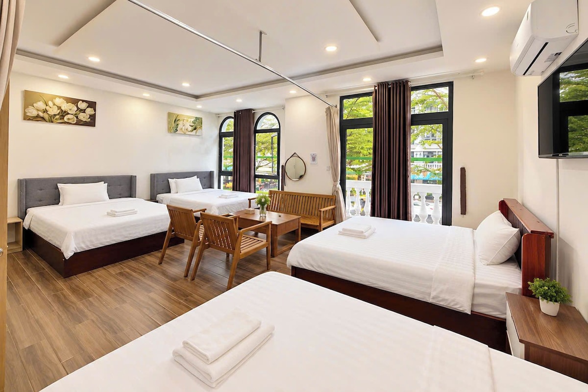 Habitación de hotel con dos camas, una mesa de comedor y una televisión.