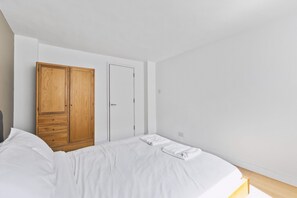 Ein Schlafzimmer mit einem Bett, einem Holzschrank und einer Tür.