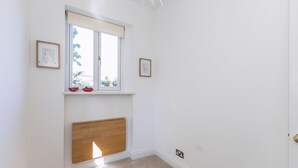 Ein Zimmer mit Fenster, Heizkörper und zwei gerahmten Bildern an der Wand.