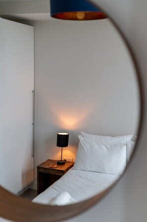 A bedroom with a bed, a nightstand, and a lamp. - Stylish 2-bed Apartment in Southwark (London)