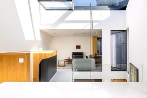Ein modernes Interieur mit Oberlicht, Essbereich und Kunstwerken an den Wänden.