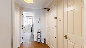 A hallway with a wooden floor, white doors, and a ceiling light fixture. - Bright Canada Water Waterside Retreat (London)