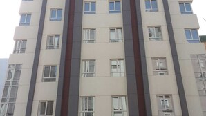 Un hotel de varios pisos con una entrada central, ventanas amplias y un diseño arquitectónico moderno.