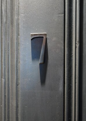 Eine Metall-Türgriff mit der Zahl 7 auf einer strukturierten Oberfläche.