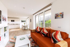 A modern apartment with a living room, kitchen, and dining area. - Stratford Flat Near Abba Arena (London)