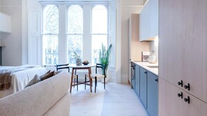 Ambiente moderno con zona pranzo, cucina e un'ampia finestra.