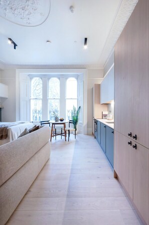 Ein modernes Interieur mit Essbereich, Küche und einem großen Fenster.