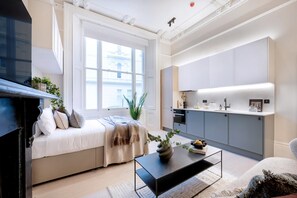Een moderne woonkamer met een bank, een salontafel en een open haard.