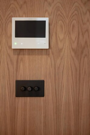 Ein Thermostat und eine Steuerung an einer Holzwand.