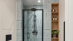 A modern bathroom with a glass-enclosed shower, a toilet, and a vanity with a mirror. - Normandy Court 11 (London)