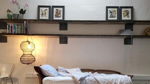 A bedroom with a bed, a patterned rug, a hanging light fixture, and framed artwork on the wall. - Architect Designed Studio Borough (London)