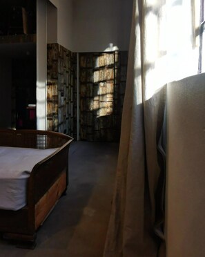 A room with a bed, a bookshelf, and a window with curtains. - Architect Designed Studio Borough (London)