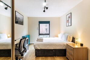 A bedroom with a bed, desk, chair, and dresser, with a window and artwork on the walls. - Bow Retreat Near Victoria Park (London)