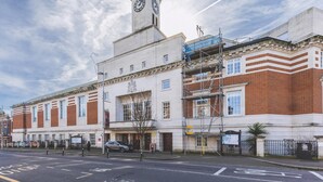 Un bâtiment historique doté d’une tour horlogée, d’une grande fenêtre et d’une enseigne.
