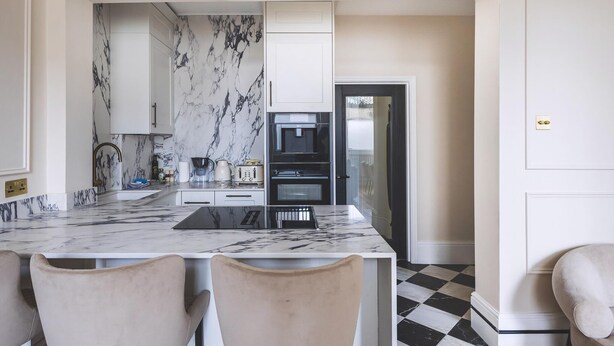 A modern kitchen with marble countertops, white cabinetry, and a checkered floor. - Elegant South Kensington Retreat (London)