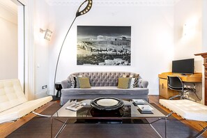 A modern living room with a sofa, coffee table, and a flat-screen TV. - Boutique Kensington Retreat Near Museums (London)