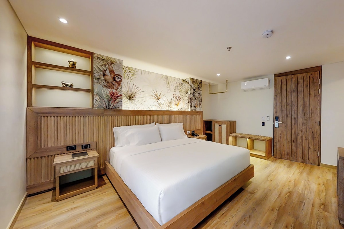 A modern bedroom with a large bed, wooden headboard, bedside tables, and a wardrobe.