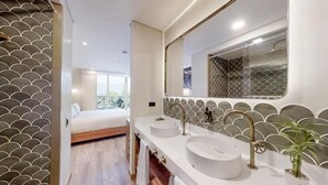 Un baño moderno con dos lavamanos, un espejo grande y un revestimiento de pared estampado.