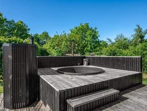 A hot tub in a wooden deck with steps leading up to it, surrounded by a fence and greenery. - "Ally" - 1.2km from the sea by Interhome (Allingåbro)