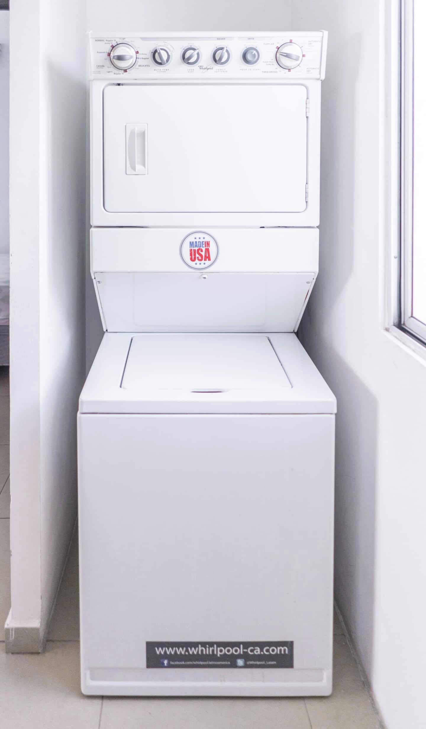 A white Whirlpool washer with a 'Made in USA' badge, a control panel with various settings, and a website URL at the bottom.
