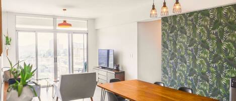 Un comedor moderno con una mesa de madera, sillas e iluminación colgante.
