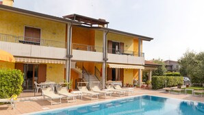 Edifici de dues plantes amb piscina, zona d'estar a l'exterior i escala que condueix al pis superior.
