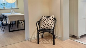 Un coin repas comprenant une table, des chaises et une étagère fixée au mur, sur laquelle est posée une image.